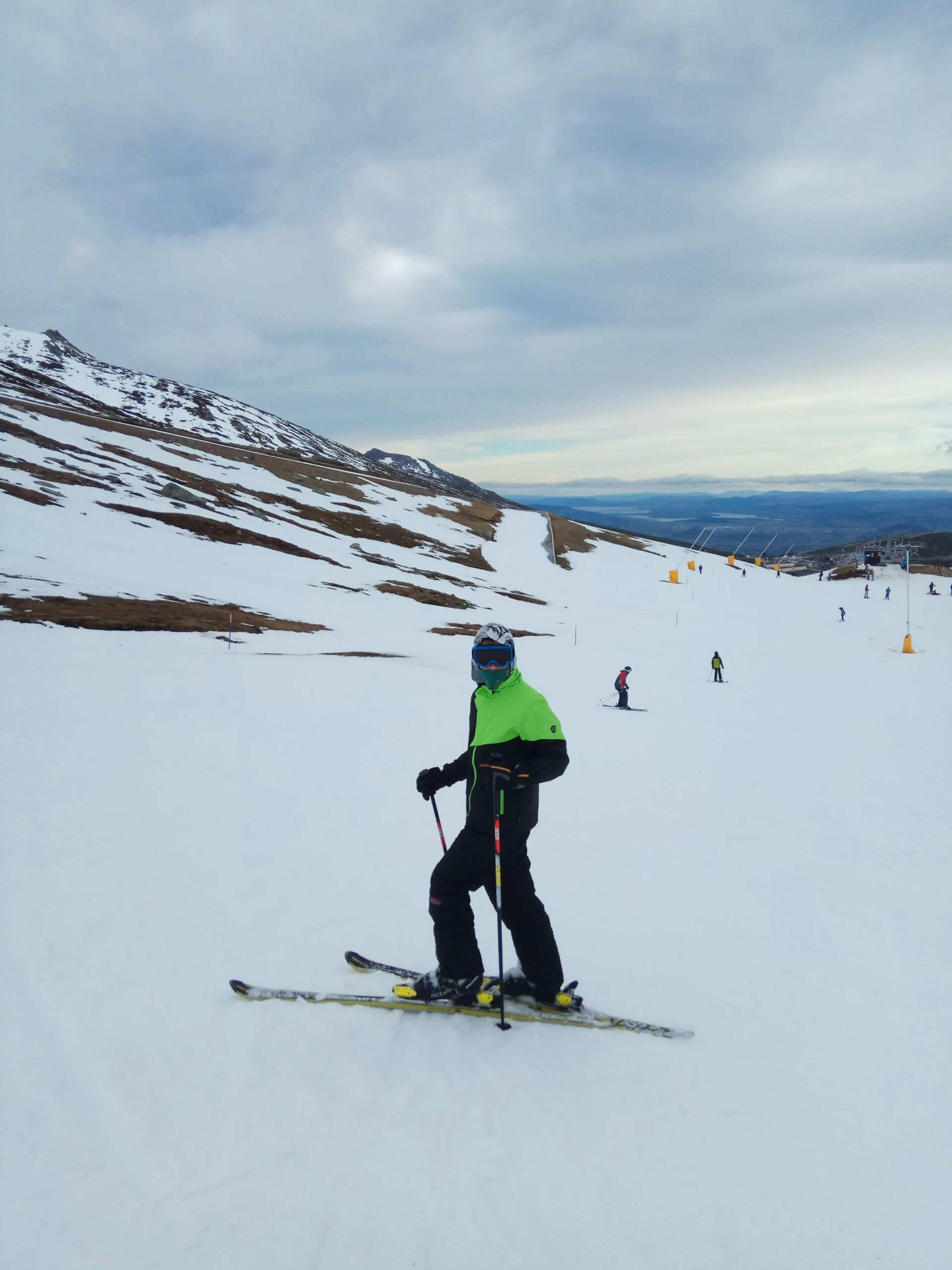 Man skiing on a snowy mountain slope at a ski resort in winter.